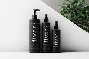 three bottles of hair products next to a plant